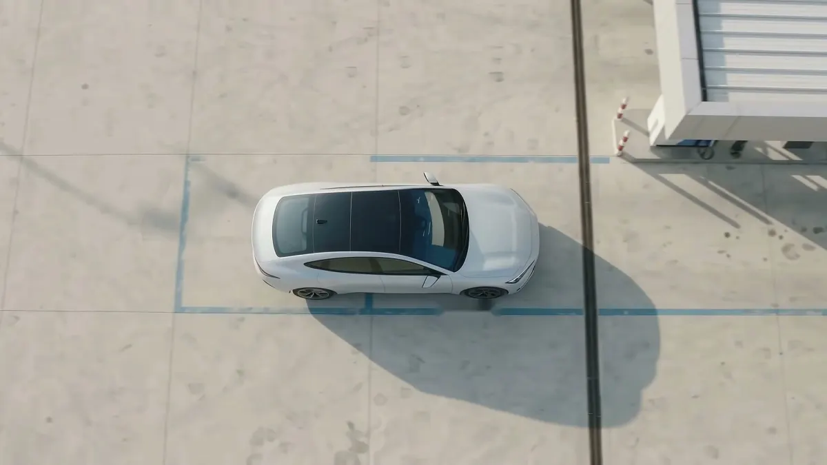 A car arriving at a service centre, seen from above, with no barrier in its path
