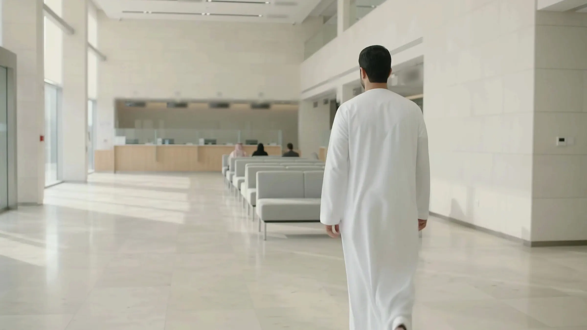 A visitor walking into a service centre, with seating and service counters ahead